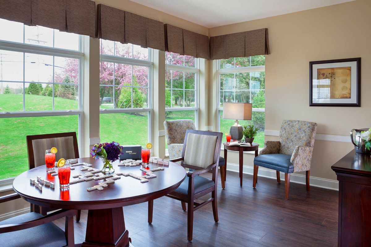 A bright dining room with a set dining table and large windows.