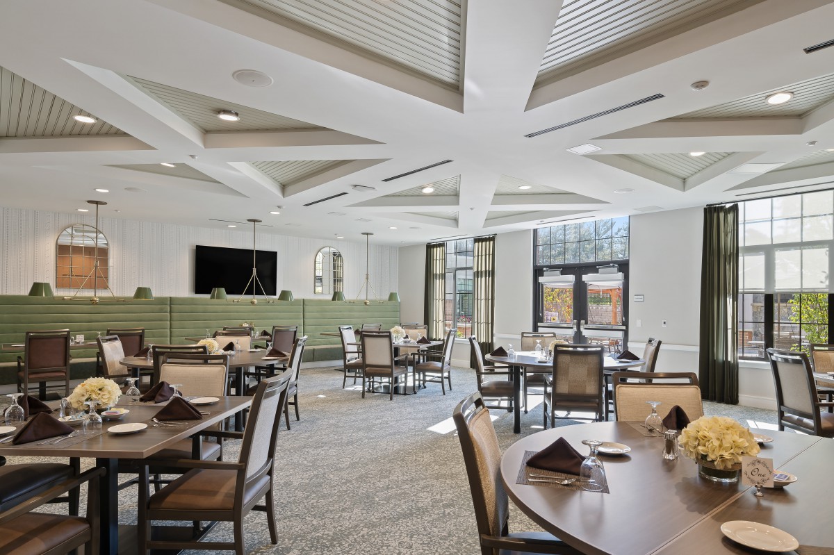 A modern dining hall with neatly arranged tables and chairs, featuring contemporary design elements.