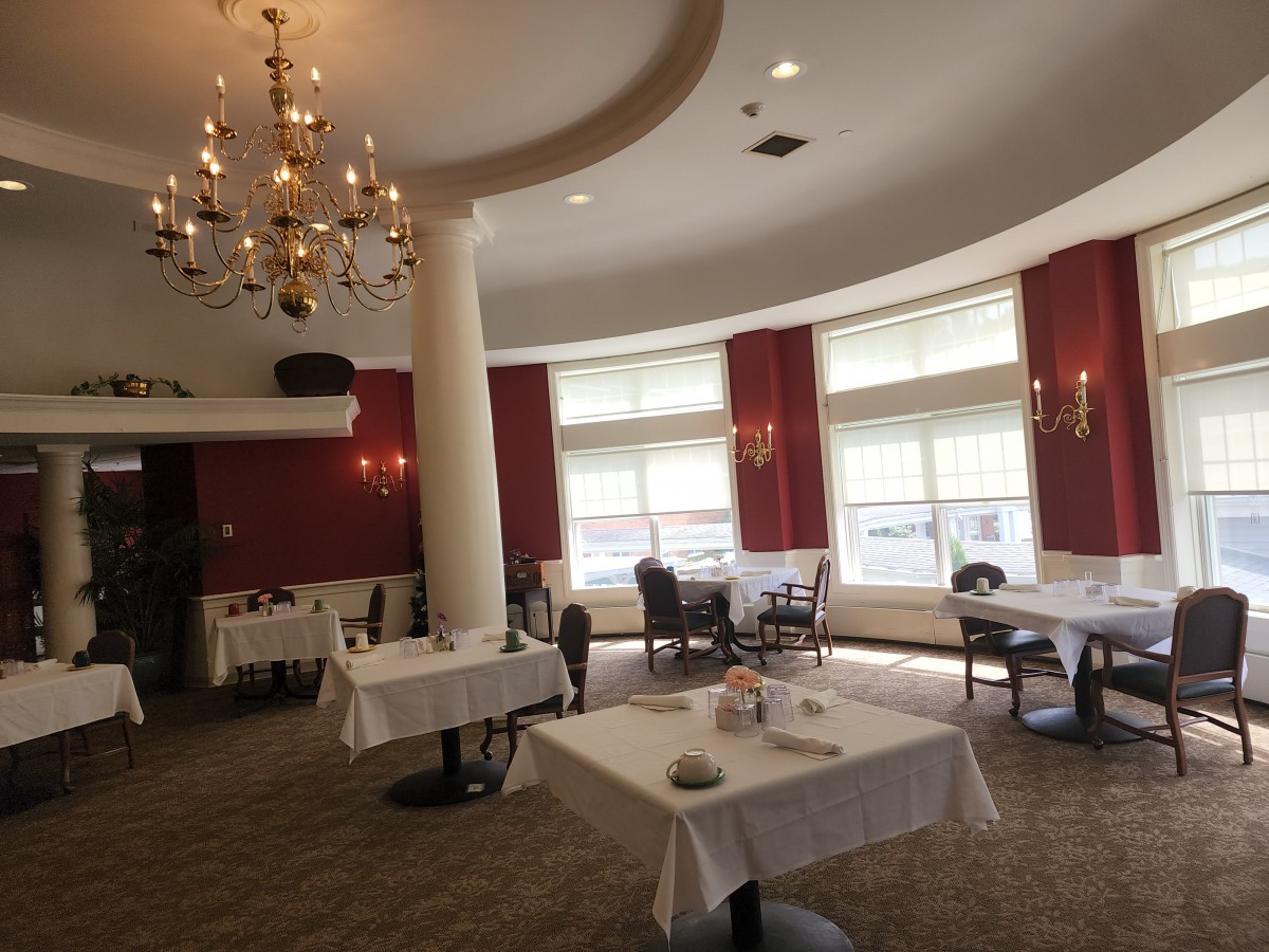 An elegant restaurant dining room featuring a chandelier and several tables.