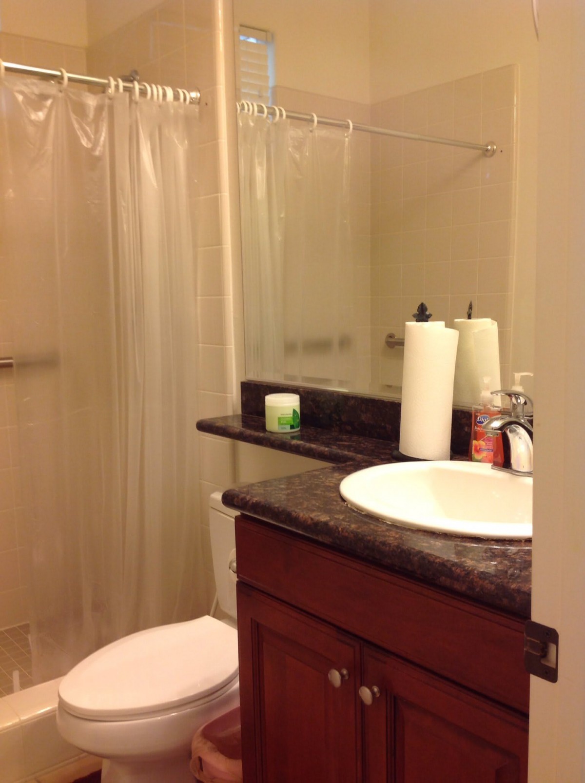 A tidy bathroom with a sink, mirror, and shower.
