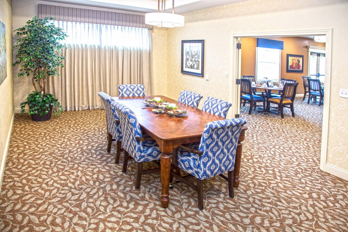 A well-decorated dining room with a wooden table and patterned chairs.