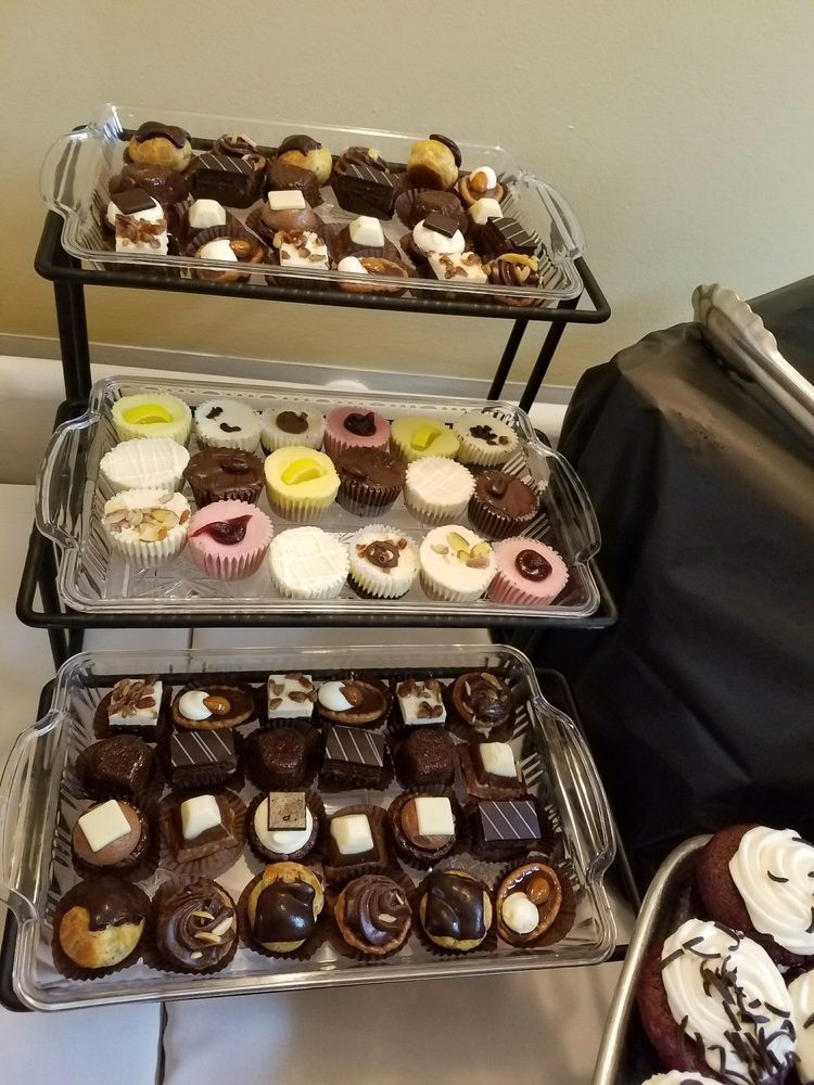 A variety of cupcakes and desserts displayed on a multi-tiered stand.
