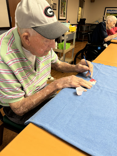 An elderly man engages in a creative craft activity, showcasing the importance of art therapy for seniors.
