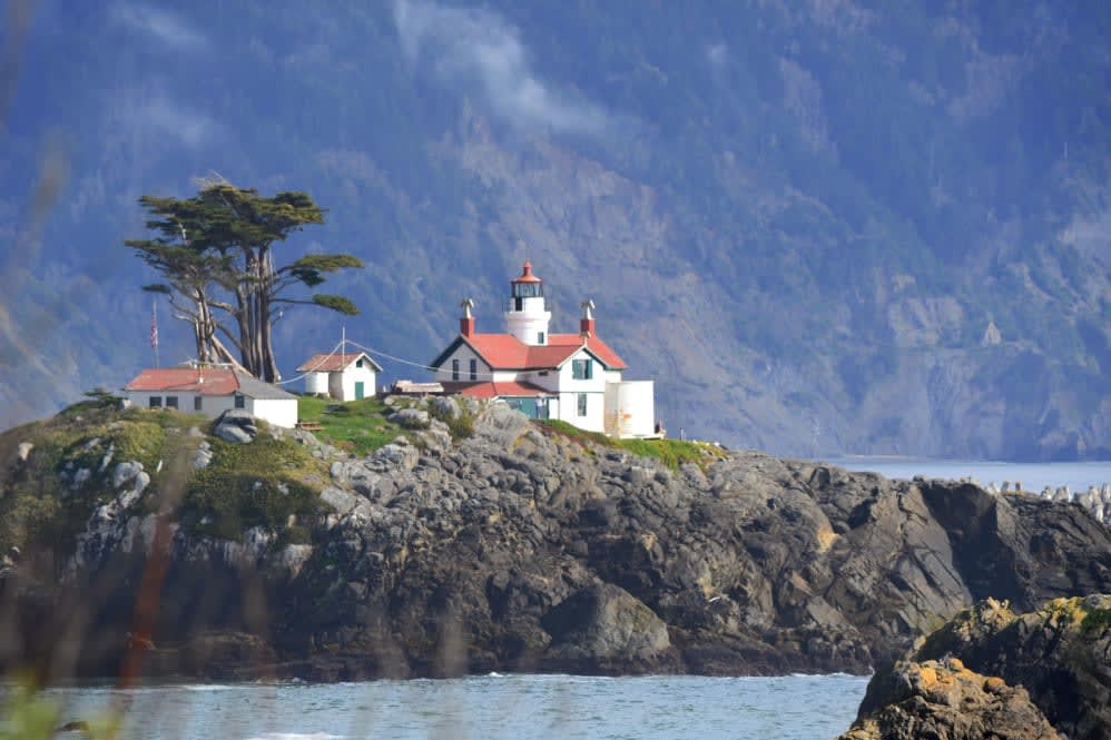 A scenic view of a lighthouse perched on a rocky coastline.
