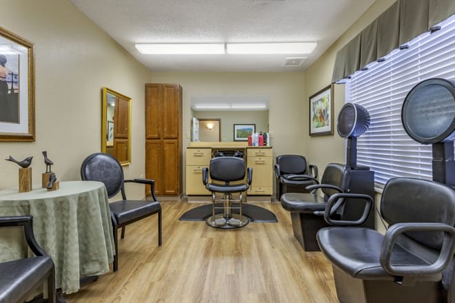 A cozy salon interior with chairs, a mirror, and hair styling equipment.