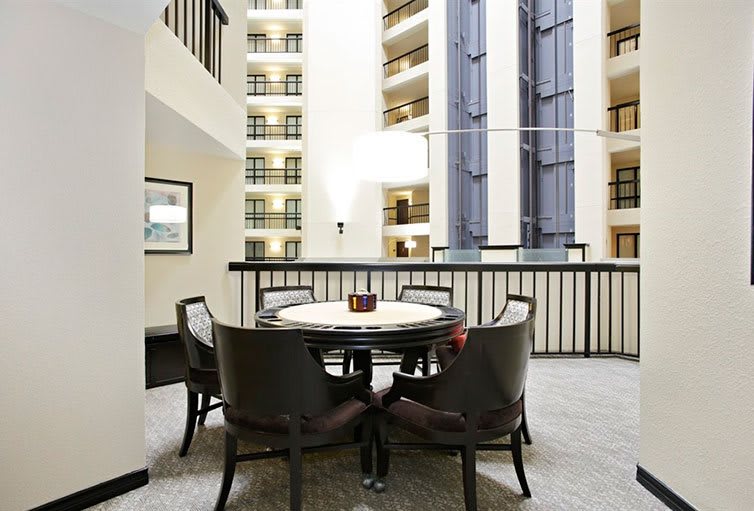 A modern hotel atrium with a circular table and chairs.