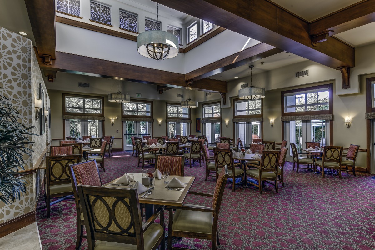 A spacious dining area with elegant furniture and ample natural lighting.
