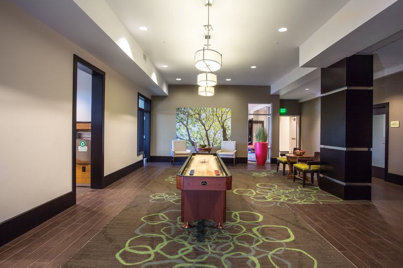 Modern interior featuring a shuffleboard table in a game room setting.