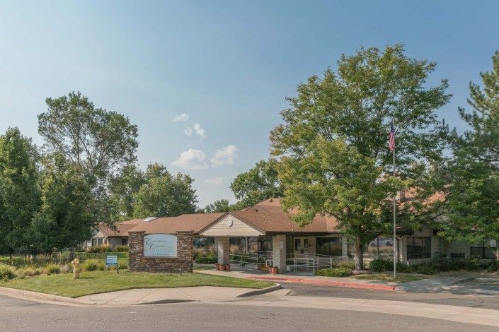 A community building surrounded by trees under a clear sky.
