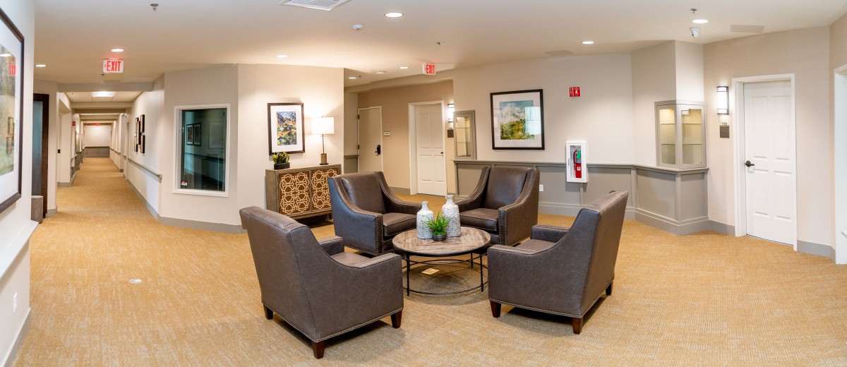 A cozy seating area with four chairs arranged around a coffee table in a lobby.