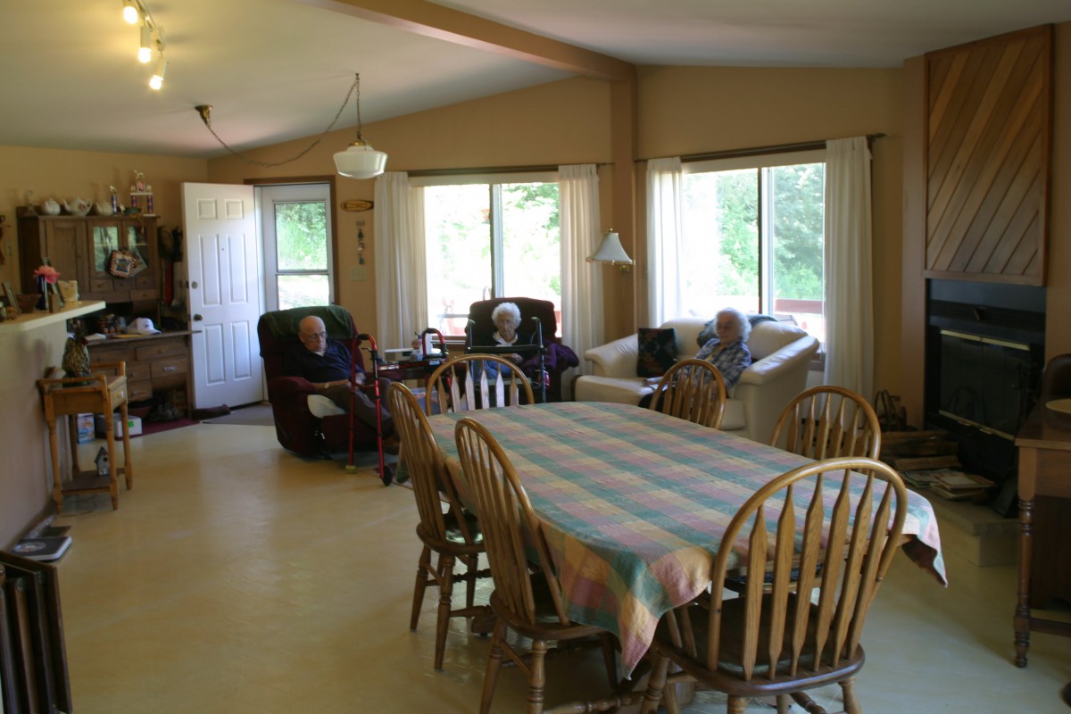A cozy living room with a dining table and comfortable seating near large windows.