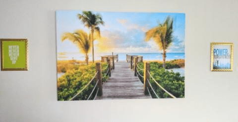 A picturesque boardwalk leading to a tropical beach at sunset.