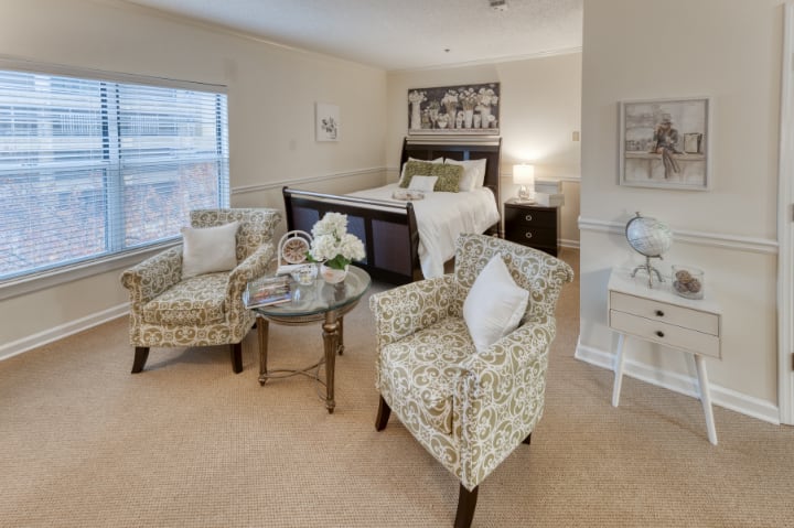 A cozy bedroom with floral-patterned chairs and elegant decor.