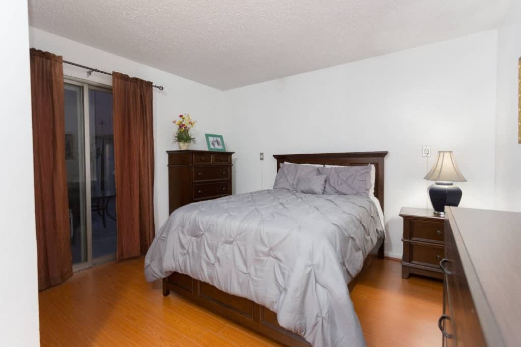 A cozy bedroom with a wooden bed and matching furniture set.