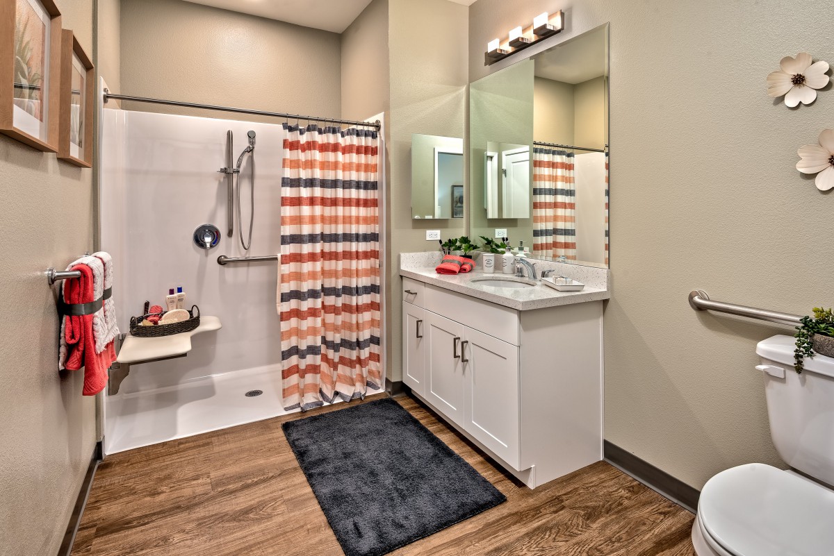 A modern bathroom with a colorful shower curtain and sleek vanity.