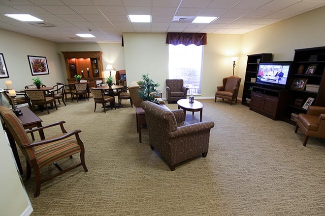 A cozy living room with comfortable seating, a television, and warm lighting.