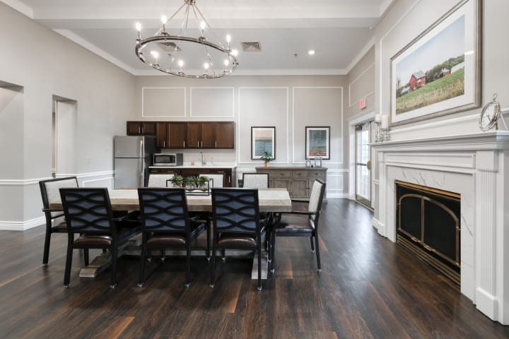 A modern dining area with a wooden table, stylish chairs, and an open kitchen layout.