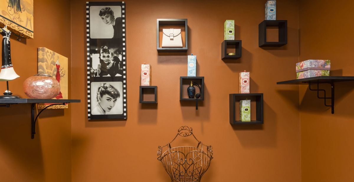 A stylish wall with vintage photos, watches, and perfume bottles artfully arranged.