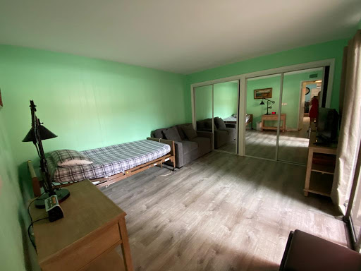 A cozy room featuring green walls and simple furnishings, perfect for relaxation.