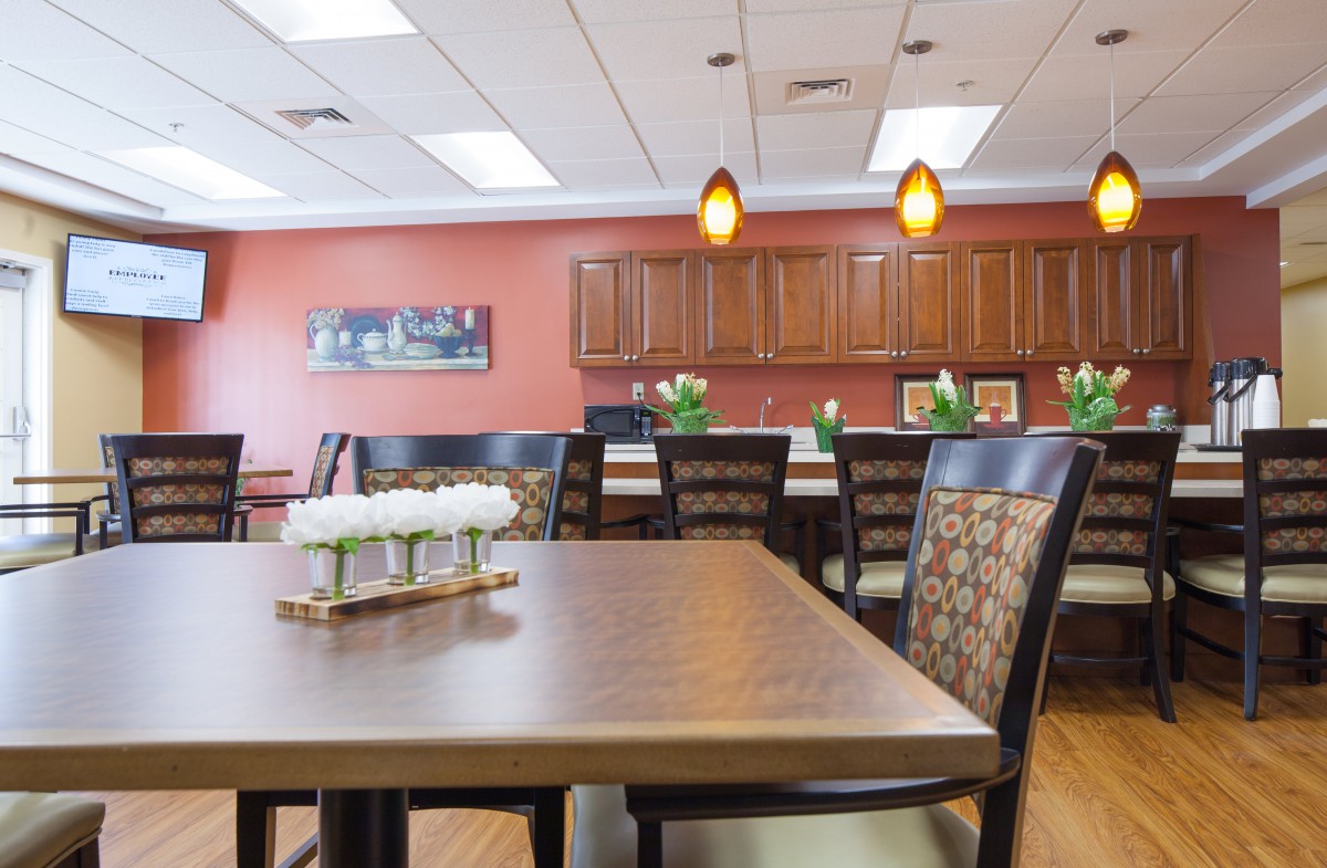 A modern dining room with a wooden table, chairs, and pendant lighting.