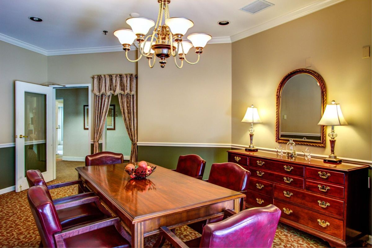 A well-furnished dining room with a wooden table, chairs, and elegant lighting.