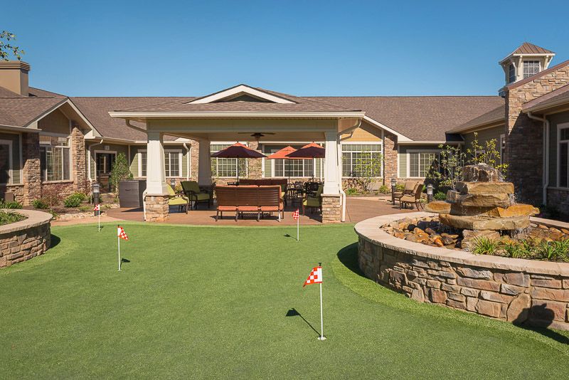 An outdoor view of a retirement home featuring a putting green and patio.