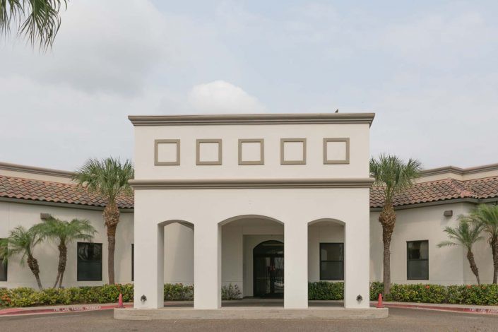 A modern building with an arched entrance and rectangular windows.