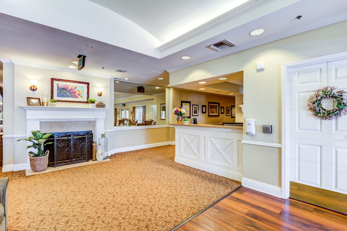 A warm and welcoming reception area with a desk, fireplace, and stylish decor.