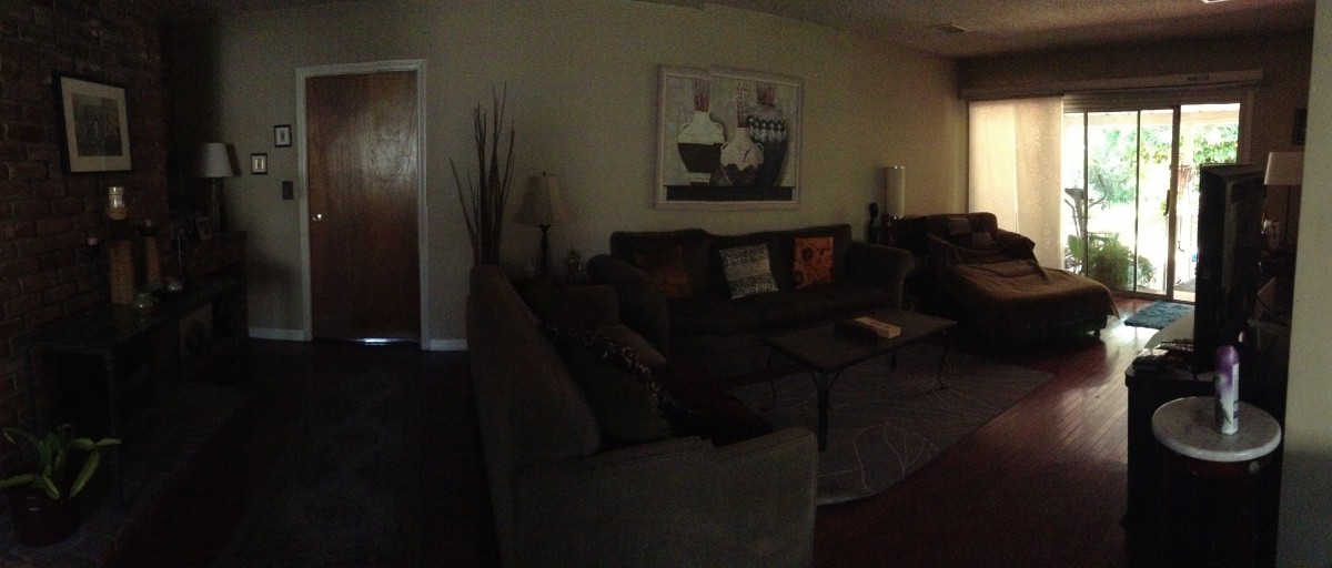 A cozy living room with a large sofa and decorative artwork on the wall.