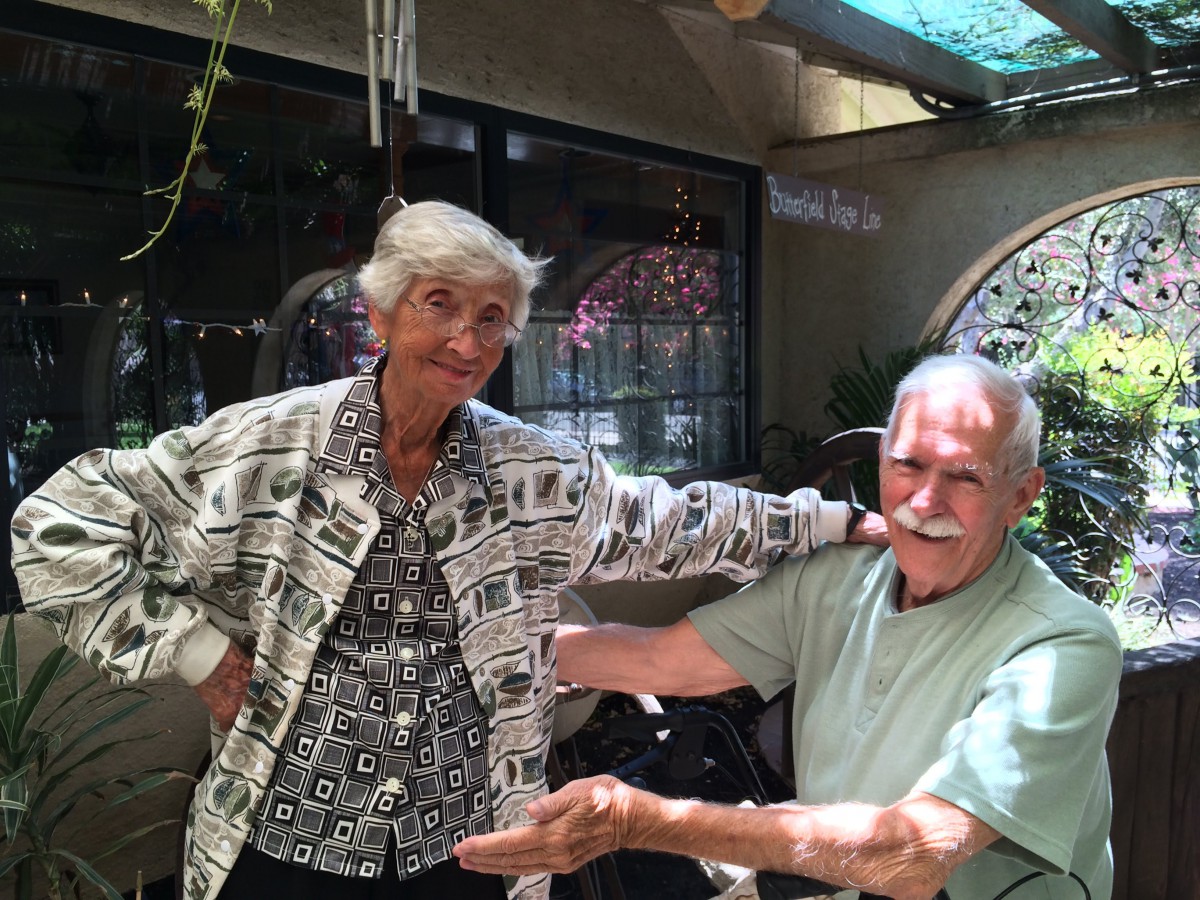 Two elderly people enjoying a moment together indoors.