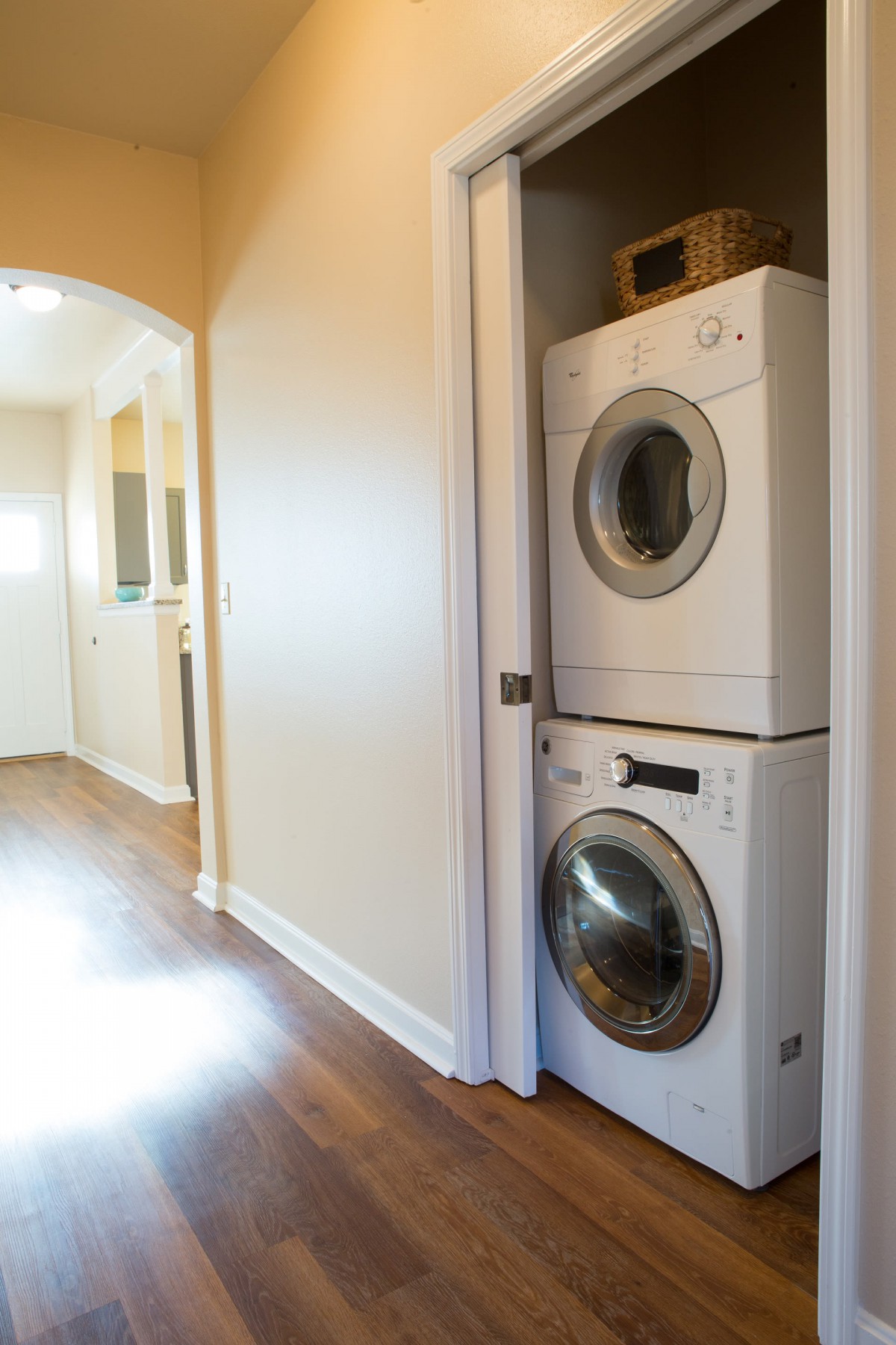 Stacked washer and dryer in a hallway of a home.