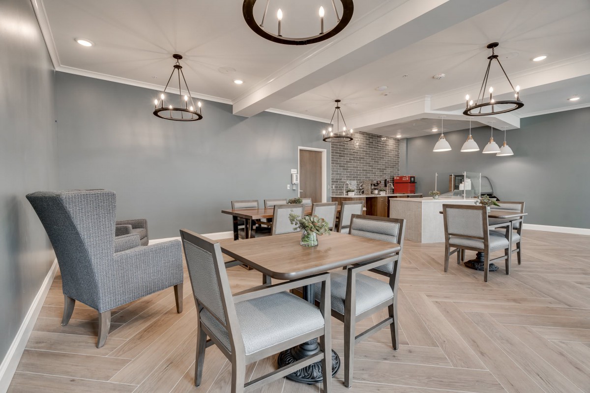 A modern dining area with elegant chandeliers and an open kitchen space.
