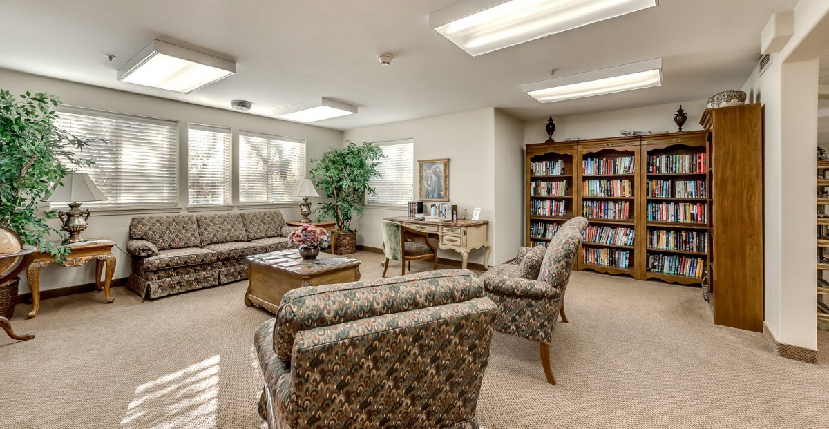 A cozy waiting room with comfortable seating and a well-stocked bookshelf.