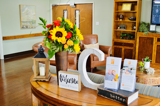 A warm and inviting reception area featuring vibrant flowers and a welcoming sign.