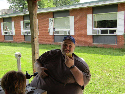 A person enjoying a snack outdoors on a sunny day.
