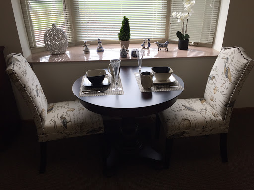 A cozy dining setup featuring a round table and stylish chairs, adorned with decorative elements.