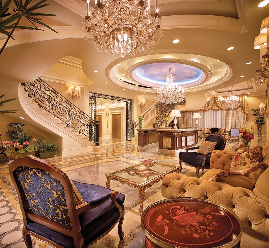A lavishly decorated living room with a grand chandelier and opulent furnishings.