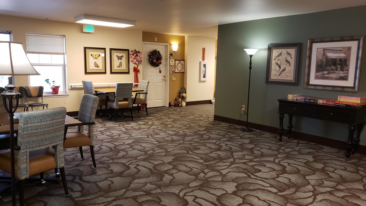 A cozy hallway with decorative artwork, seating area, and ambient lighting.