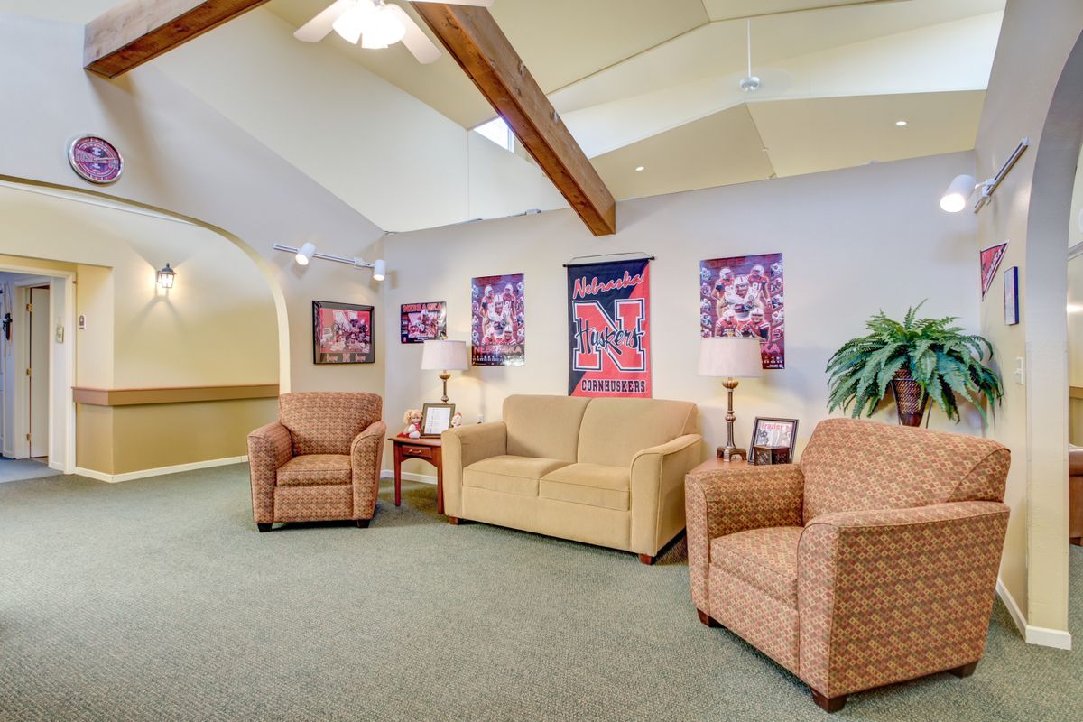 A cozy waiting room featuring comfortable seating, colorful artwork, and warm lighting.