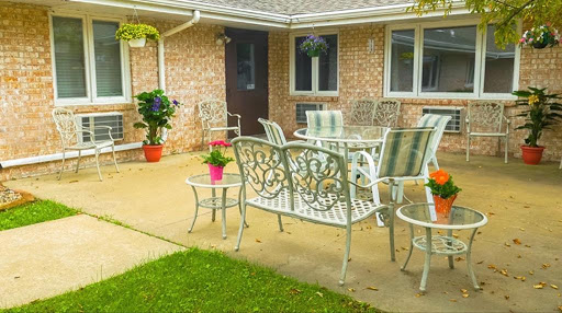 A cozy outdoor patio setup with metal furniture and vibrant potted plants.