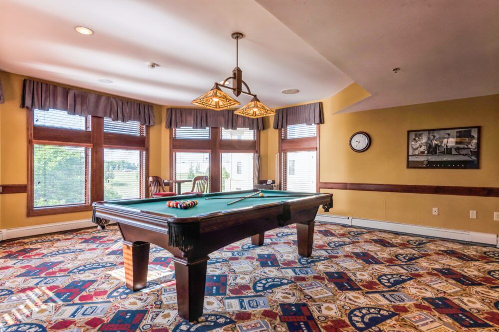 A cozy game room featuring a billiard table and elegant lighting.