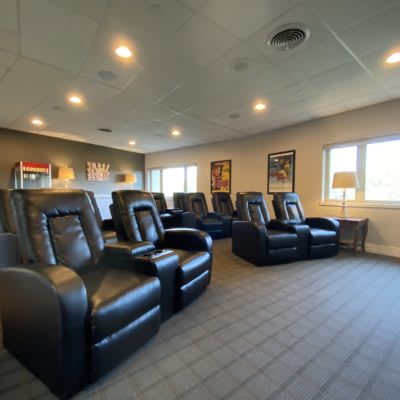 A modern home theater with comfortable recliner seating and ambient lighting.