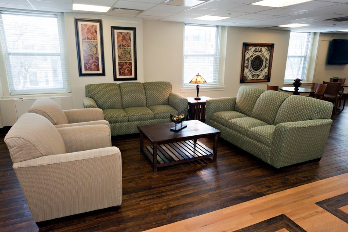 A cozy living room with sofas, armchairs, and a coffee table.
