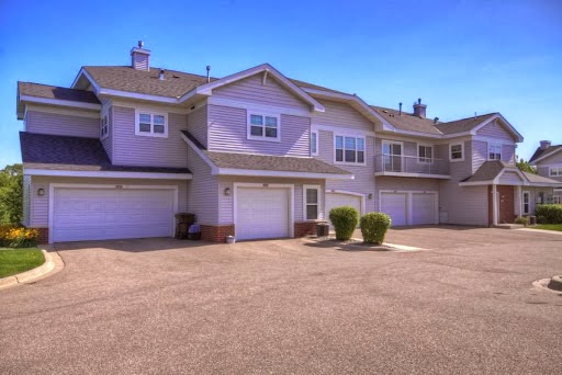 A view of a modern residential apartment complex featuring garages and well-maintained landscaping.