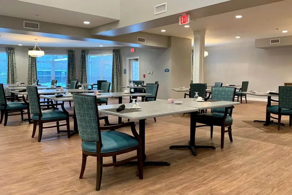 An empty dining area with neatly arranged tables and chairs in an indoor setting.