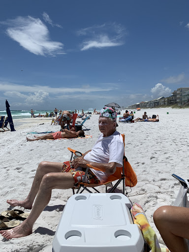 A sunny day at the beach with people enjoying their time on the sand.