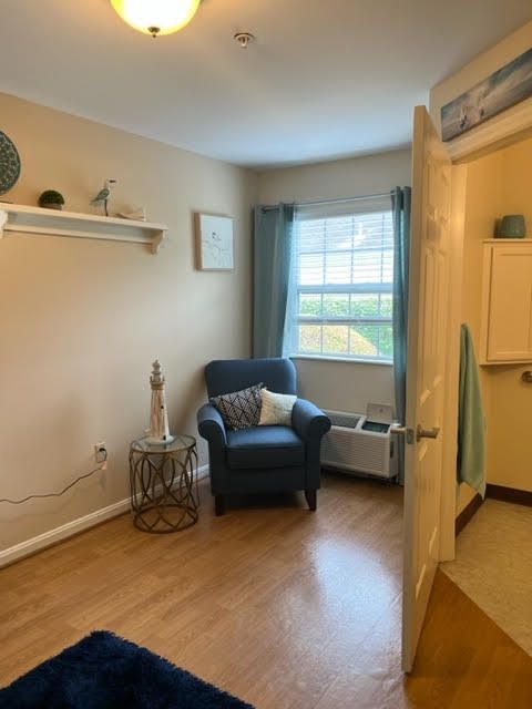 A cozy living room corner with an armchair and window.