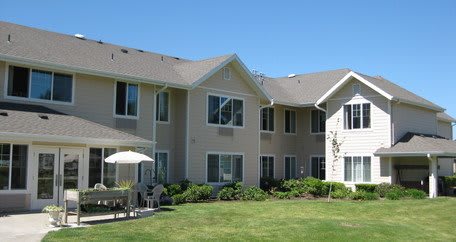 A modern residential apartment building with landscaped surroundings.