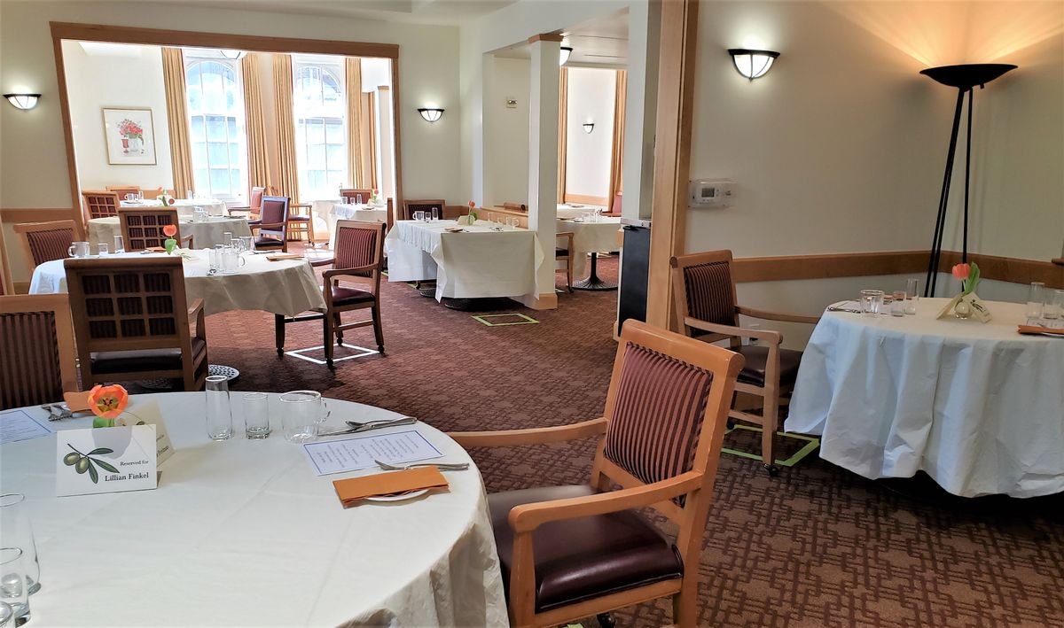 An empty restaurant dining room with neatly arranged tables and chairs.