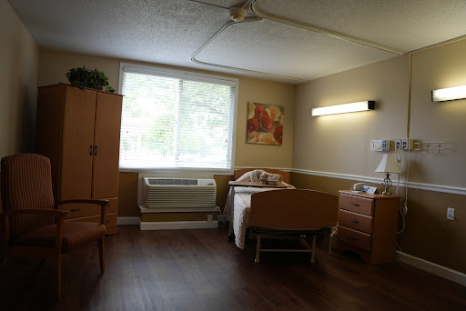 A cozy room featuring a bed, furniture, and natural light from the window.
